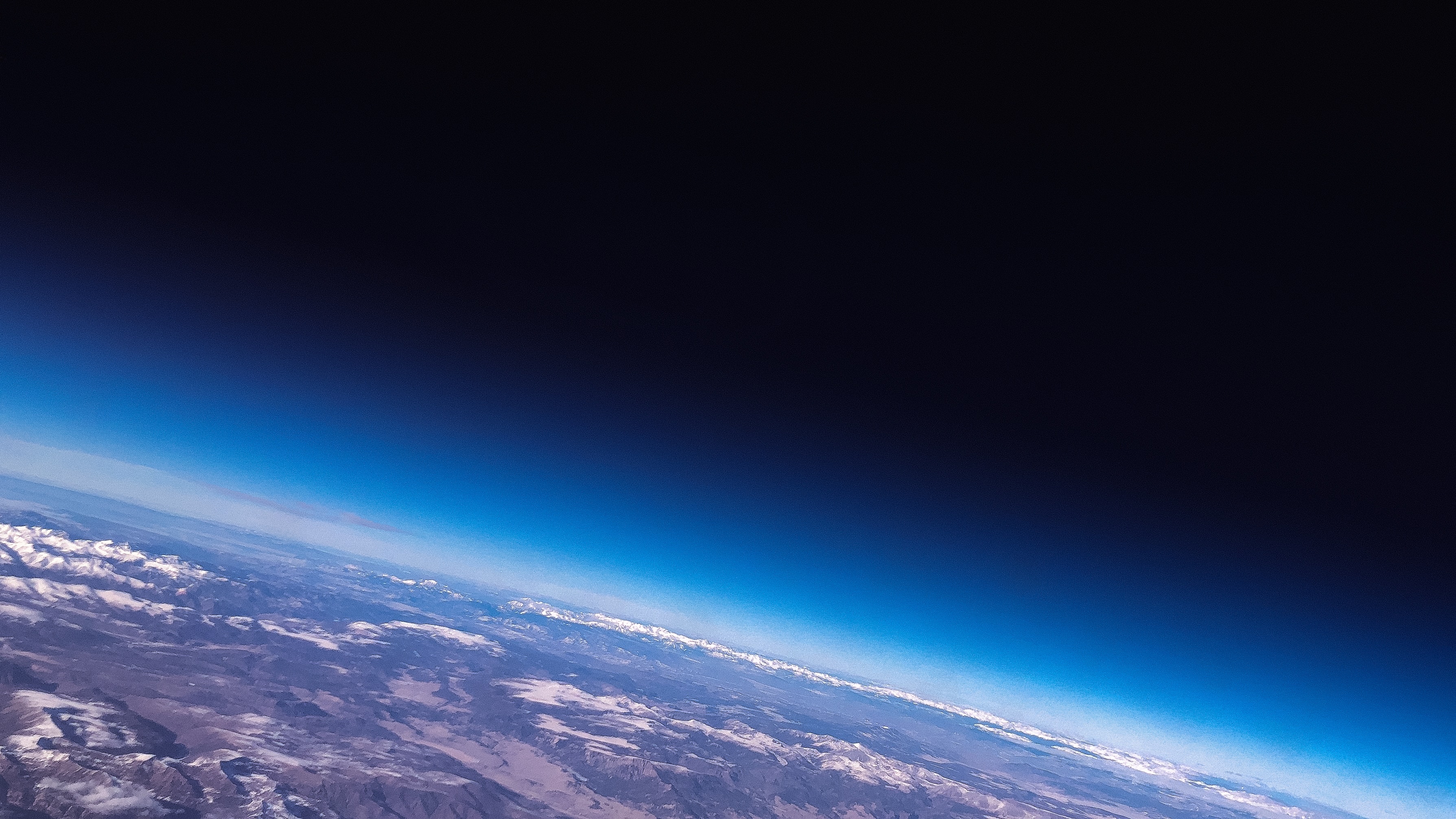 The background image of this site, a photo of Earth from space. The camera is close enough that Earth is only partially visible, and one can see its atmosphere around the planet.